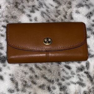 Tan leather Coach wallet has slight wear damage on inside. Previously loved.